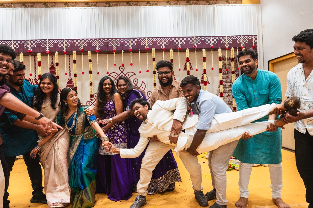 Engagement — Friends lifting groom in fun celebration chaos