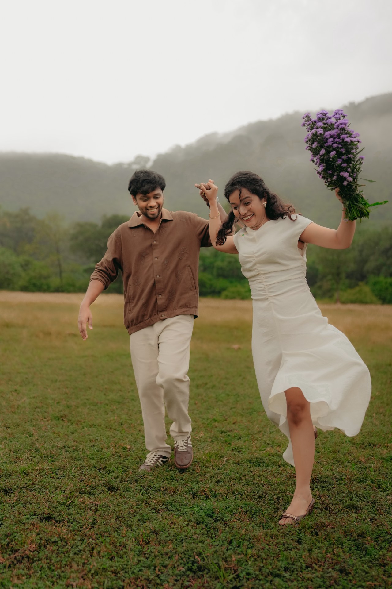 Pre-Wedding — Karthik & Mirunalini dancing in misty meadow with purple bouquet