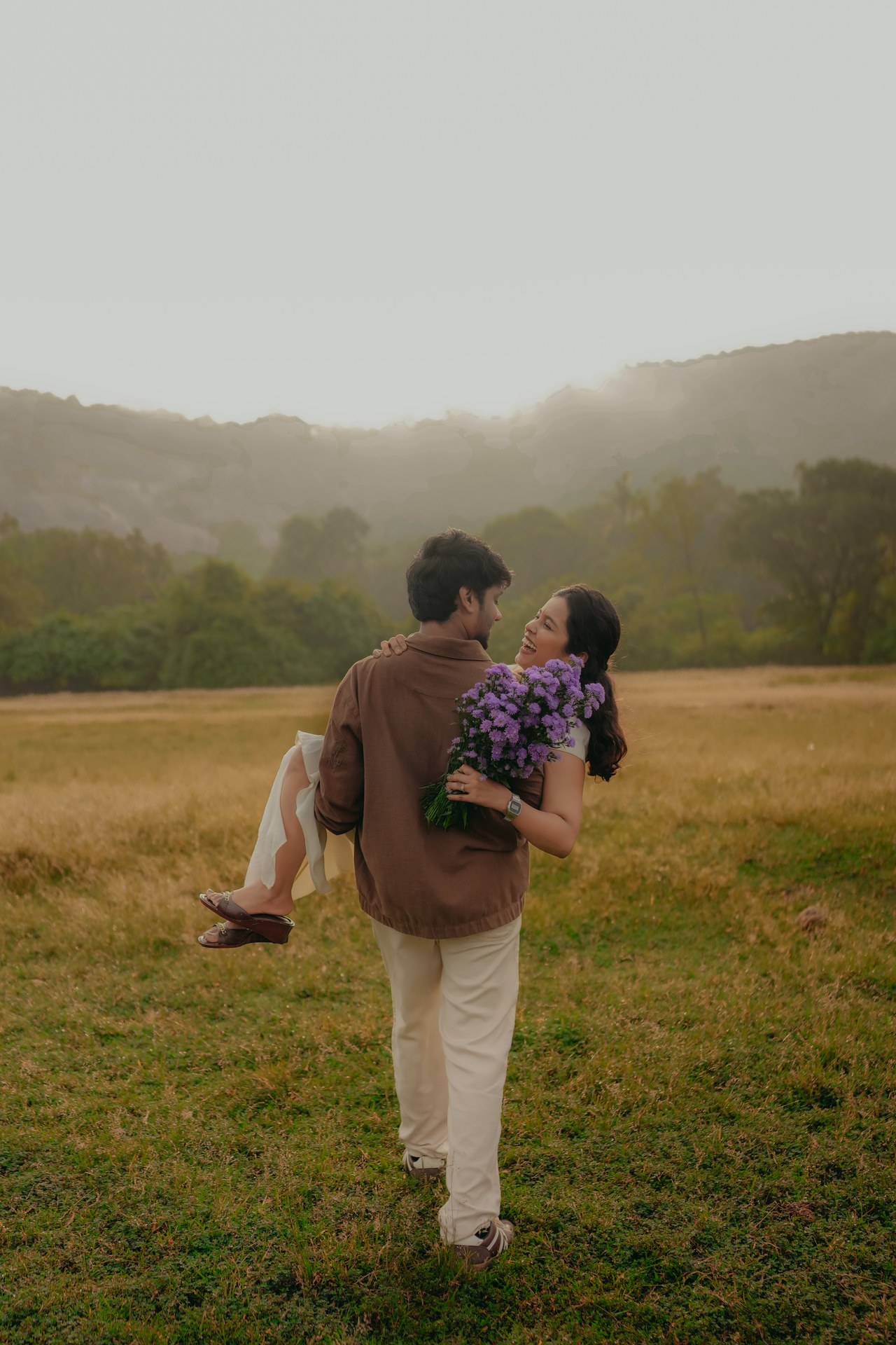 Pre-Wedding — Karthik carrying Mirunalini in golden-hour meadow