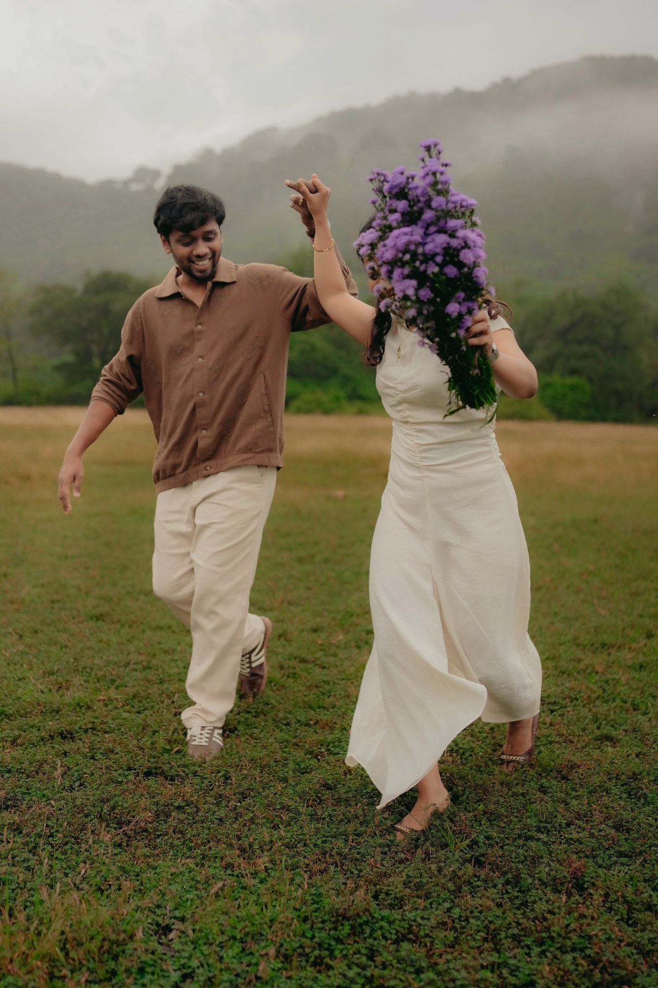 Pre-Wedding — Couple sitting together laughing in meadow with purple flowers